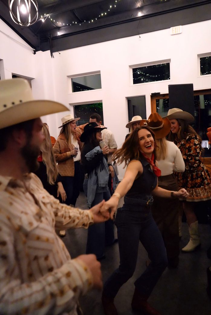 Guests line dancing in cowboy hats